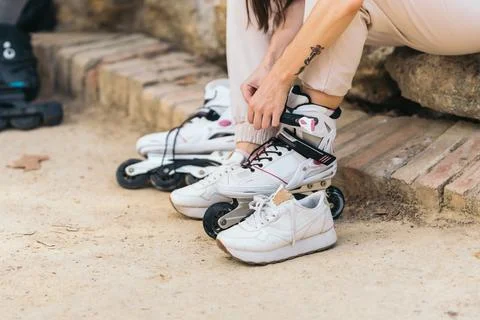 Unrecognizable woman puting on inline skates in a park Stock Photos