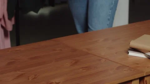 An unrecognizable woman puts a stack of clothes on the table. Close-up Stock Footage 161269407