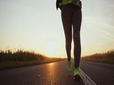 Unrecognizable Woman Running on Country Road at Sunrise. STABILIZED SLOW MOTION Stock Footage