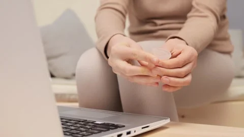 Unrecognizable woman sitting on couch using laptop for writing review of Vídeo Stock 257056731