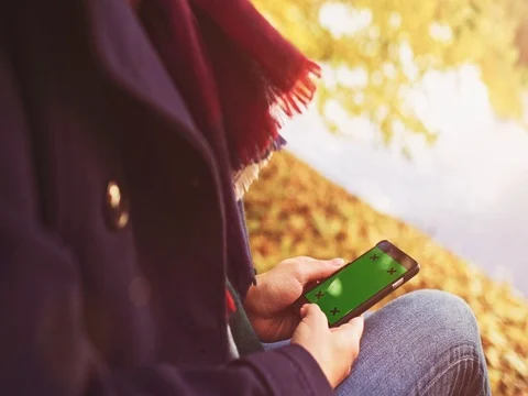 Unrecognizable Woman Using SmartPhone with Green Screen in Autumn. SLOW MOTION. 動画素材 79631948
