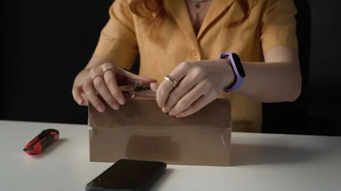Unrecognizable Woman Using Utility Knife to Open Cardboard Box Stock Footage 332734233