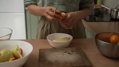 Unrecognizable womans hands peeling and slicing a fresh banana with a knife to Stock Footage 320724685