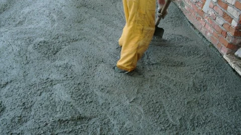 Unrecognizable worker spreading the raw concrete near the house with shovel Stock Footage 285338008