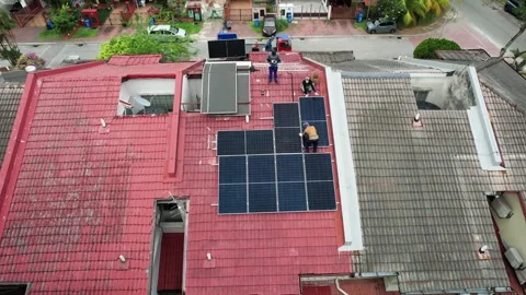 Unrecognizable workers installing solar photovoltaic or PV panels onto red Stock Footage 342265595