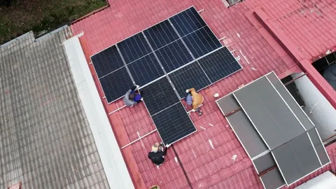 Unrecognizable workers installing solar photovoltaic or PV panels onto red Stock Footage 342265657