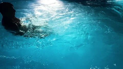 Unrecognizable young couple having relax in pool illuminated with night lights Stock Footage 251479685