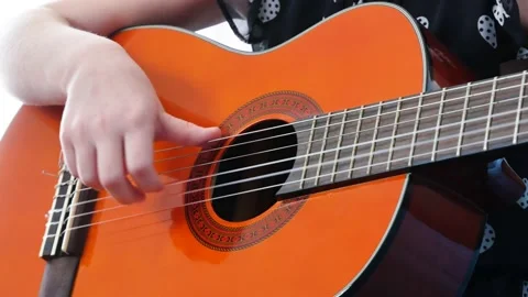 Unrecognizable young girl, school age child practicing playing acoustic guitar Stock Footage 152990153