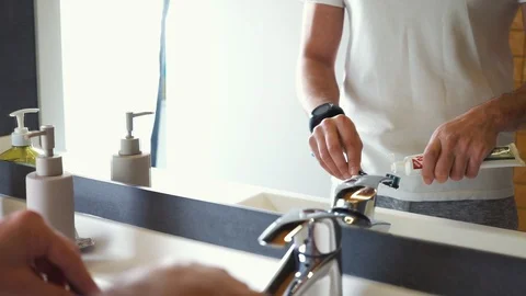 Unrecognizable young man in the bathroom prepares to brush his teeth In Bathroom Stock-Footage 121003123