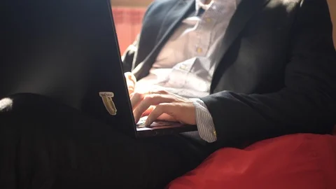 Unrecognizable young man in costume working on a laptop at home Video stock 128442252
