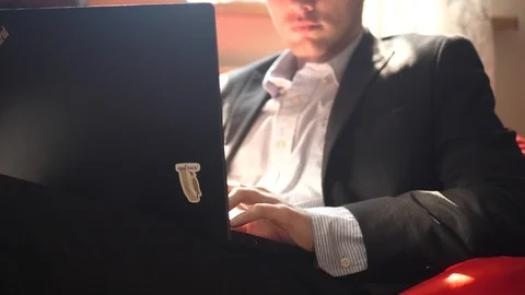 Unrecognizable young man in costume working on a laptop at home Video stock 128442285