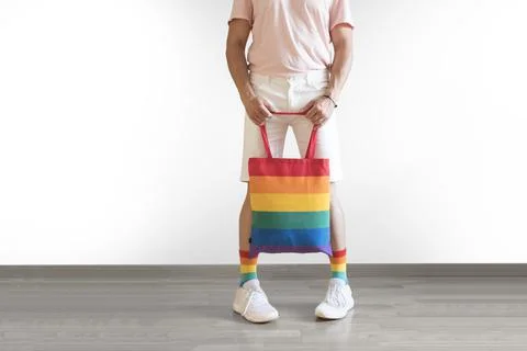 Unrecognizable young man posing dressed in socks and rainbow bag. Concept of Stock Photos