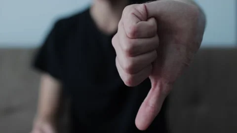 Unrecognizable young man showing a thumbs down gesture toward the camera Stock Footage 327158385