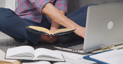 Unrecognizable young man studying online or doing homework using laptop and Stock Footage 150707749