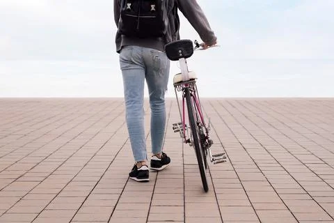 Unrecognizable young man walking with a bicycle Stock Photos