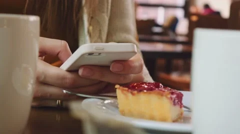 Unrecognizable Young Woman using Cellphone in a Cafe, Close Up on Hands. 4K. Stock Footage 67223137
