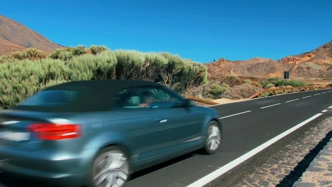 Unrecognized car drives past the camera, rides along a mountain asphalt road in Stock Footage 120210233
