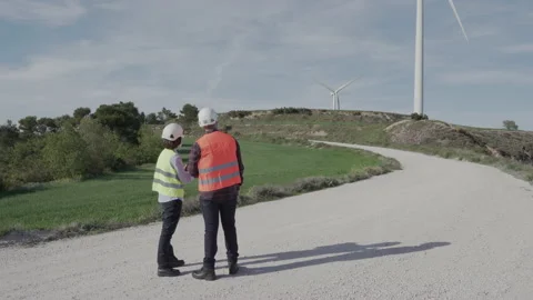 Unrecognized engineers wearing safety helmets working in wind turbine farm. Stock Footage 155295458