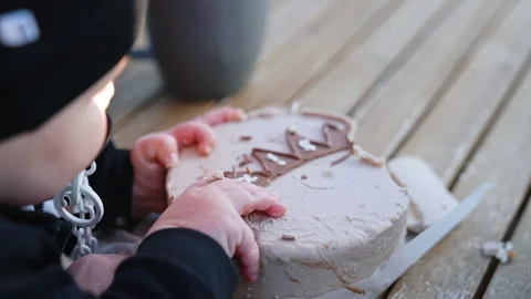 Unrecognized infant trying to grab a cake in front of him Stock Footage 253238989