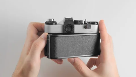An unrecognized man opens the body of an old retro vintage photo camera to Stock Footage 121644408