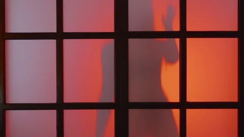 Unrecognized model dances behind matt glass at colorful light flashes,slow mo,4k Stock Footage 244726785