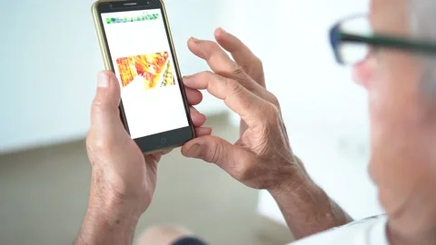 Unrecognized old man with glasses using a mobile phone at home. Stock Footage 157790166