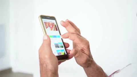 Unrecognized old man surfing the internet using a mobile phone at home. Stock Footage 157734191
