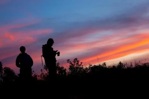 Unrecognized people using a celular smartphone in a mountain landscape Stock Photos