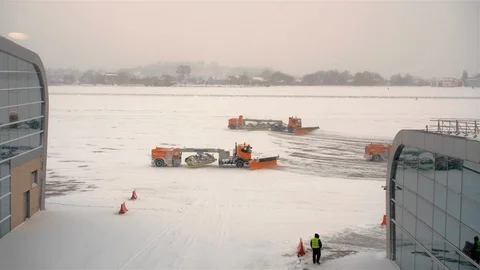 Unrecognized pink-colored plane takes off in a snowstorm. It leaves a trail of Stock Footage 119513810