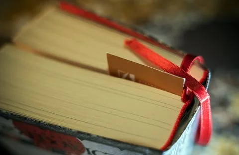 An unrecognized random book close up with silk thread bookmark along with a p Stock Photos