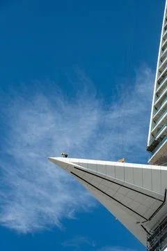 Unrecognized worker at the edge of an extension of a skyscraper building Stock Photos