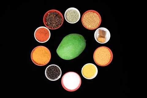 Unripe mango different type of spices filled in bowls in circular shape Foto stock