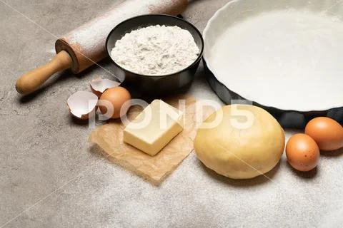 Unrolled and unbaked Shortcrust pastry dough recipe on concrete background Stock Photos