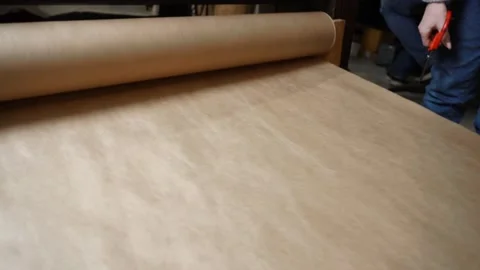 Unrolling Kraft Paper Roll by Hand for Packaging Stock Footage 315528636