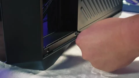 Unscrewing bottom screw of computer case side panel Stock Footage 328984377