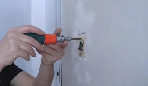 Unscrewing the old switch case with a screwdriver Stock Photos