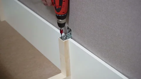 Unscrews the screw with a screwdriver in the sofa Stock Footage 147378723
