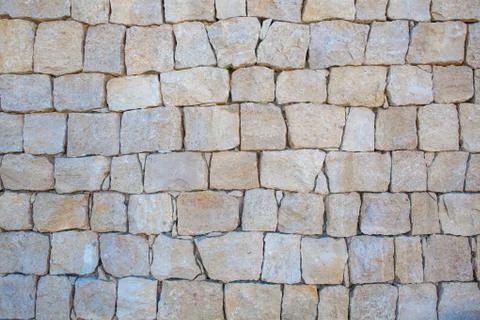 Unshaped stone wall pattern ,wall made of rocks . Stock Photos
