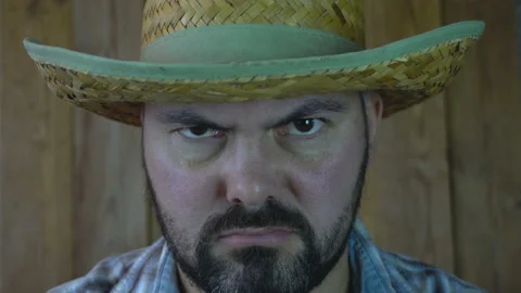 The unshaven man in a straw hat looking serious 4K Video stock 95924445