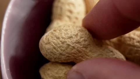 Unshelled peanuts and hand taking one nut Stock Footage 311810158