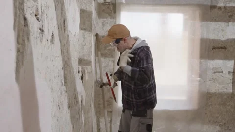 Unskilled construction worker at a building site using chisel and hammer su.. Vídeos de archivo 307856610