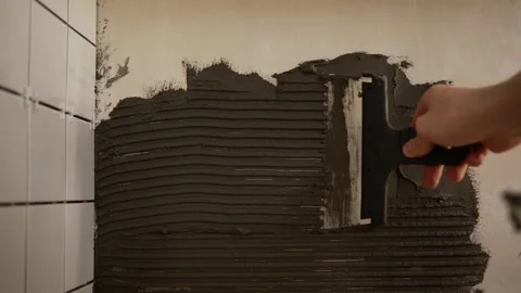 Unskilled man saving money during crisis, learning tiling and applying adhesive Stock Footage 330187779