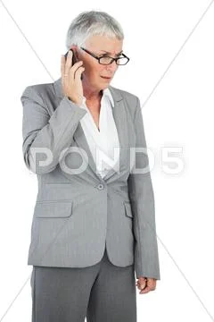 Unsmiling businesswoman calling someone with her mobile phone Stock Photos