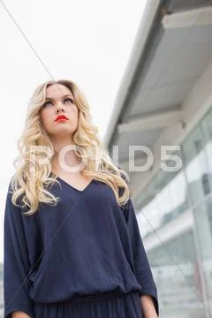 Unsmiling gorgeous blonde with red lips posing outdoors Stock Photos