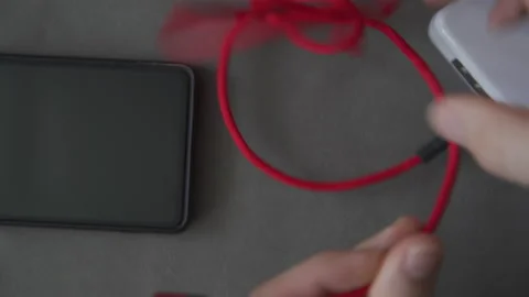 Untangling the very long cable from the phone charger Stock Footage 237349672
