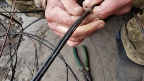 Untwisting a tie on a coil of wire Stock Footage 266353657