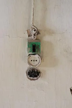Unused light switch and socket on the wall in the apartment of an old non-res Stock Photos