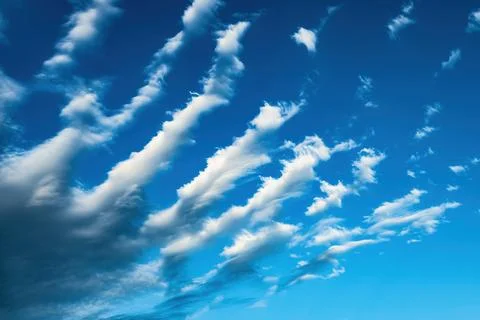 Unusual cirrus clouds forming parallel stripes across the blue sky in summe.. 写真素材