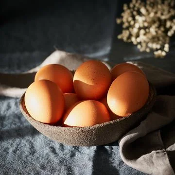 Unusual Easter on dark background. Bowl of brown eggs on dark blue table, f.. Stock Photos
