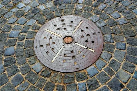 Unusual pavement with creative concentric pattern from metal decorative plate Foto stock